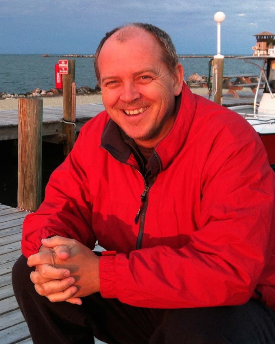 Emile du Toit, founder of BrainIT Consulting, smiling on a wooden dock